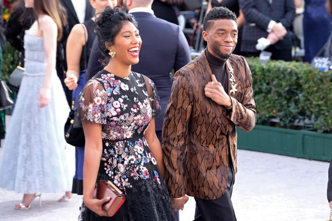 Theo Oprah Magazine, Boseman dẫn bạn gái đến bữa tiệc sau buổi quảng bá phim Black Panther (2018), sự kiện công chiếu phim 21 Bridges. Sau đó, họ tiếp tục được chú ý khi cùng đi xem trận đấu bóng rổ NBA All-star. Trong chuyến đi, diễn viên Michael B. Jordan cũng có mặt. Nhiều lần xuất hiện cùng nhau nhưng truyền thông vẫn không biết lý do anh chưa vội công bố chuyện tình cảm. Ảnh: Splash News.