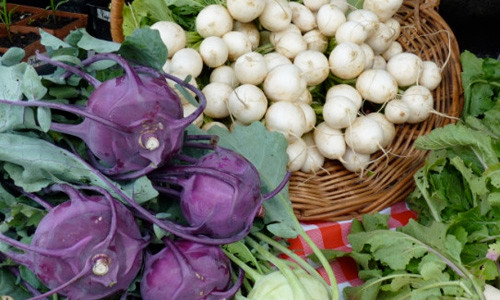 Hình ảnh su hào tím nổi bật và thu hút hơn hẳn so với các loại rau củ khác trên sạp hàng ở chợ.