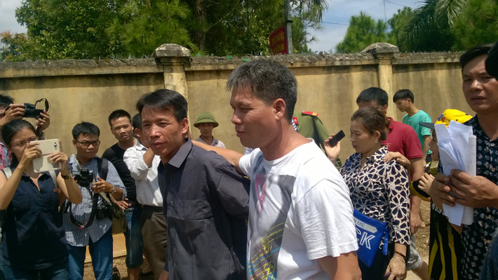 Hai anh em ông Vươn khoác vai nhau đi ra khỏi cổng trại giam trong niềm hân hoan, chào đón của mọi người.