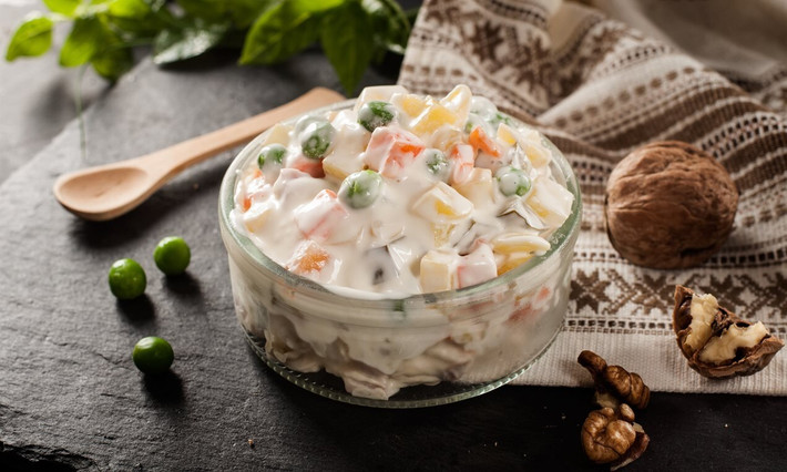 Món ngon này là hỗn hợp gồm các loại rau củ, dưa chuột muối, trứng luộc thái nhỏ, sốt mayonnaise chuẩn vị Nga và dăm bông/xúc xích.