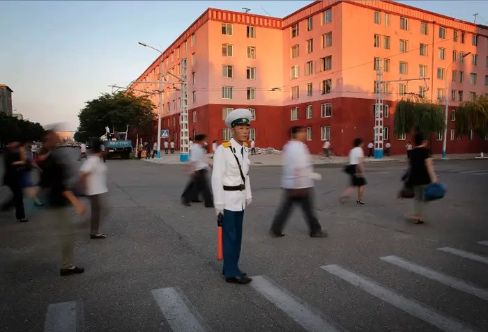 Cảnh sát giao thông hướng dẫn người đi bộ tại Quảng trường Kim Il ở Bình Nhưỡng. Ảnh: AP.