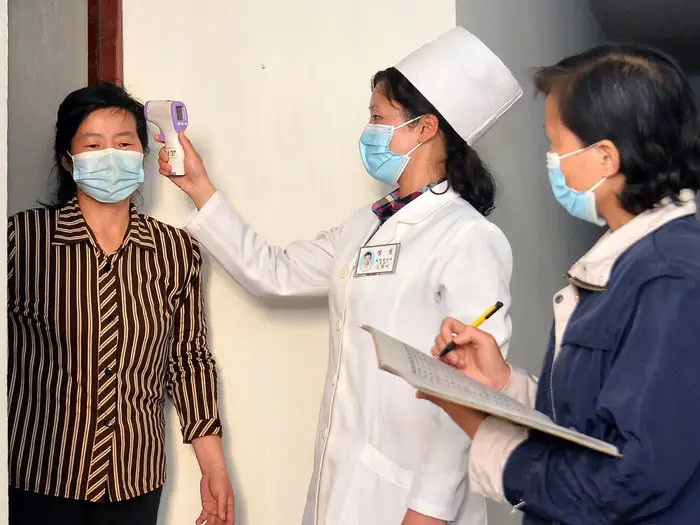 Bác sĩ kiểm tra nhiệt độ của một người dân để hạn chế sự lây lan của Covid-19, tại Bình Nhưỡng. Ảnh: AP.