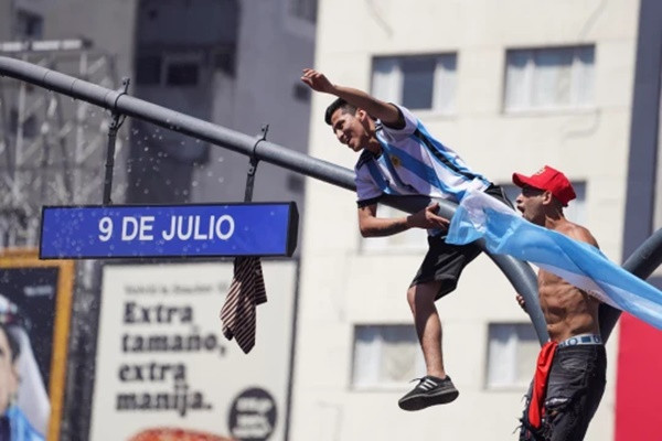 Cổ động viên Argentina leo cột đèn ăn mừng chiến thắng. Ảnh: AP.