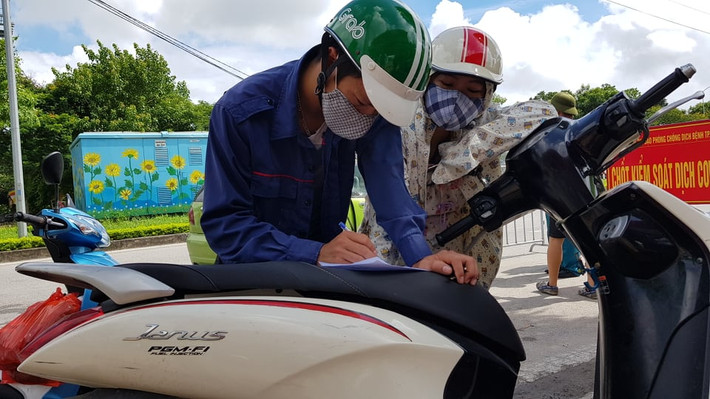 Một số người dân phải khai báo y tế trên yên xe.