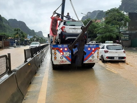Đường ngập, không ít xe ô tô phải nhờ đến xe cứu hộ.