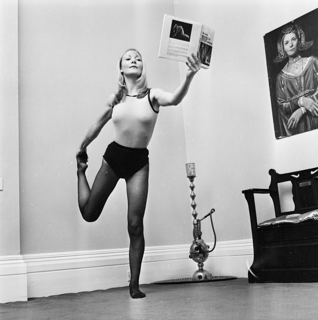 Ca sĩ người Anh Christine Holmes tập yoga trong căn hộ của mình năm 1974. Cô vừa tập yoga vừa đọc sách.