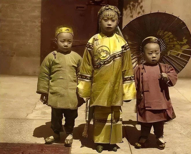 Ba đứa trẻ xuất thân trong gia đình giàu có mặc những bộ trang phục truyền thống được làm từ chất liệu đắt tiền.