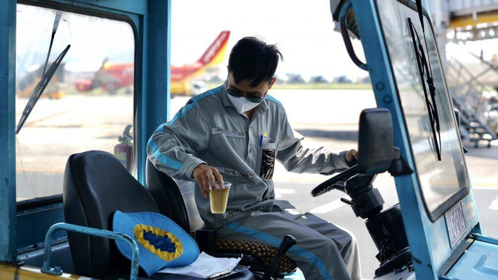 Một công nhân lái xe tranh thủ uống nước giải nhiệt.