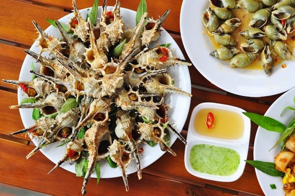 Ốc gai nướng là một trong những món ngon tuyệt cho bữa trưa mà bạn nên thưởng thức. Thịt ốc gai không thanh ngọt như vị vốn có của các loài ốc mà béo, giòn, bùi, đăng đắng đó là điểm đặc trưng tạo nên dấu ấn riêng của loại ốc này.