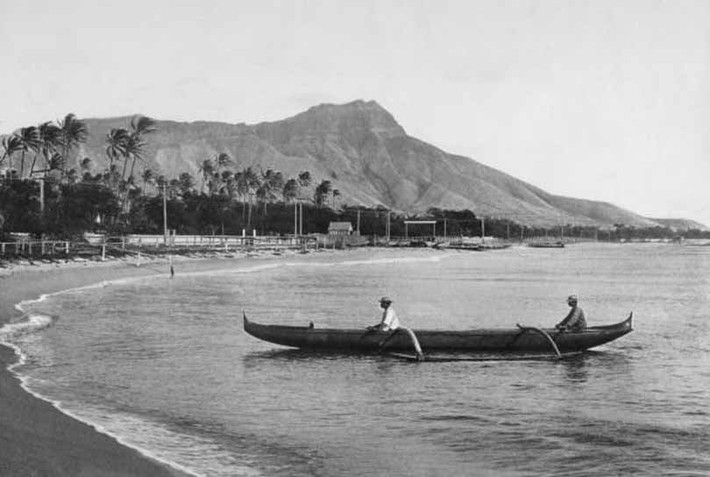 Đầu những năm 1900: Hai người đàn ông địa phương chèo thuyền về nghỉ ngơi bên bãi biển tại Vịnh Waikiki. Ảnh: Getty.