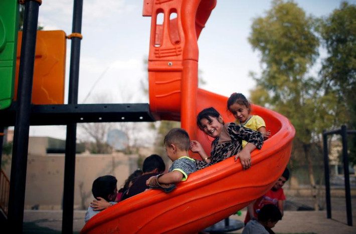 Trẻ em Yazidis chơi trò trượt máng ở Sinjar. Ảnh: Reuters.