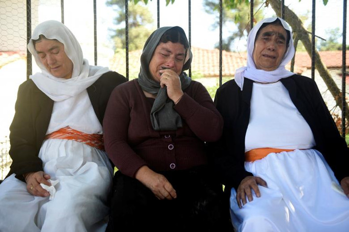 Những người phụ nữ Yazidi đau buồn khi nhớ tới những người quá cố. Ảnh: Reuters.