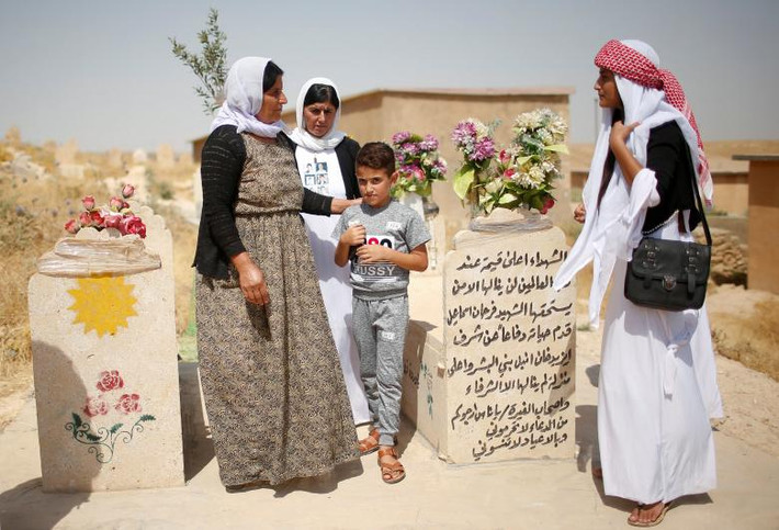 Những người Yazidi thăm nghĩa trang để tưởng nhớ những người thiệt mạng trong cuộc thảm sát 3 năm trước ở Sinjar. Ảnh: Reuters.