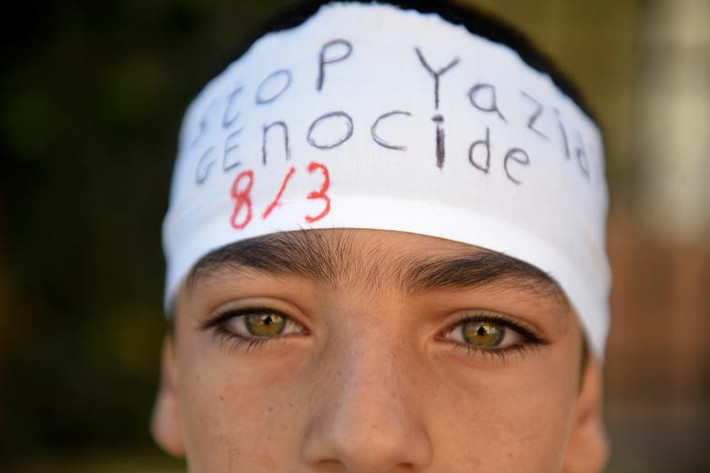 Một cậu bé người Yazidi tham gia lễ tưởng niệm những người quá cố trong cuộc thảm sát. Ảnh: Reuters.
