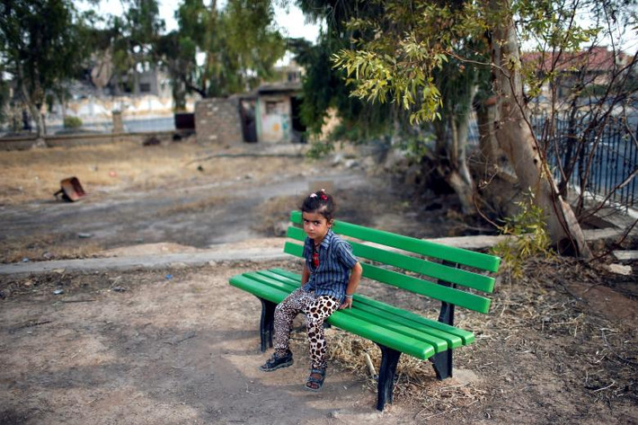 Một cô gái Yazidi ngồi ở sân chơi trong khu vực Sinjar. Ảnh: Reuters.