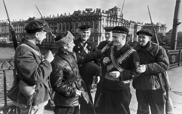 Các công nhân nhà máy Kirov trò chuyện vui vẻ với các thủy thủ Liên Xô trên một cây cầu. Khi Leningrad bị phát xít Đức vây hãm, họ trở thành những người lính dũng cảm trong cuộc chiến bảo vệ quê hương.