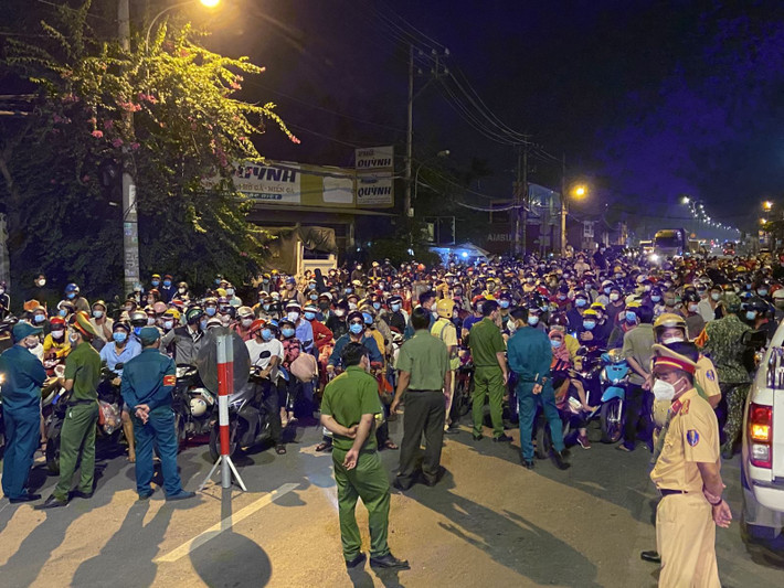 Lực lượng chức năng tuyên truyền, yêu cầu người dân quay về nơi cư trú; tuy nhiên, nhiều người vẫn cố bám trụ, chờ được thông qua để về nhà. Ảnh TTX.
