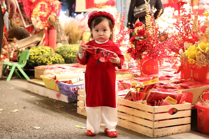Các em nhỏ cũng được bố mẹ diện bộ đồ Tết rực rỡ lên Hàng Mã dạo phố.