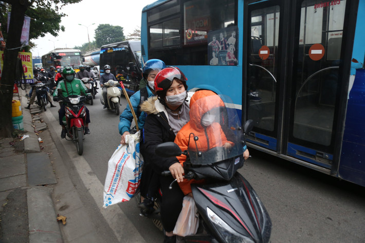 Một gia đình trở lại Hà Nội bằng xe máy sau kỳ nghỉ dài 3 ngày.