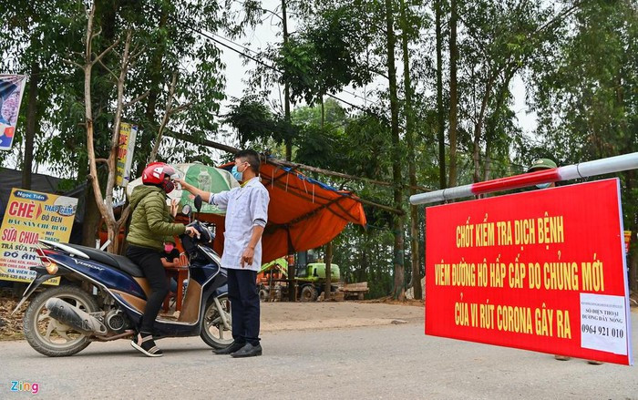 Con đường dẫn vào xã Sơn Lôi, huyện Bình Xuyên, tỉnh Vĩnh Phúc những ngày này luôn có lực lượng an ninh chốt chặn 24/24h làm công tác đo thân nhiệt người ra vào, hướng dẫn người dân đeo khẩu trang đúng cách.