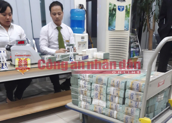 Đáng chú ý, số tiền lớn Nam khai giấu ở nhà bạn ở Quảng Ninh, khi trinh sát đến nơi, chủ nhà mới hay hai thùng đồ Nam nhờ gửi chính là thùng tiền. Trong nhà kho không có khóa cửa, ở xó nhà có hai thùng (cao 80 cm, dài hơn 2 m, rộng 80 cm) được che bạt. Cậy nắp thùng, bên trong chất các cọc tiền cao tới 40 cm. Số tiền này tổng cộng 147 tỷ đồng, 7 máy đếm tiền hoạt động hết công suất từ 17h30 đến 22h30 mới kiểm đếm xong. Trong khi đó, số tiền 300 tỷ đồng, Nam khai gửi tại nhà một người bạn ở TP HCM, nhưng khi cơ quan tố tụng xác minh thì số tiền lên tới 375 tỷ đồng. Ảnh: CAND