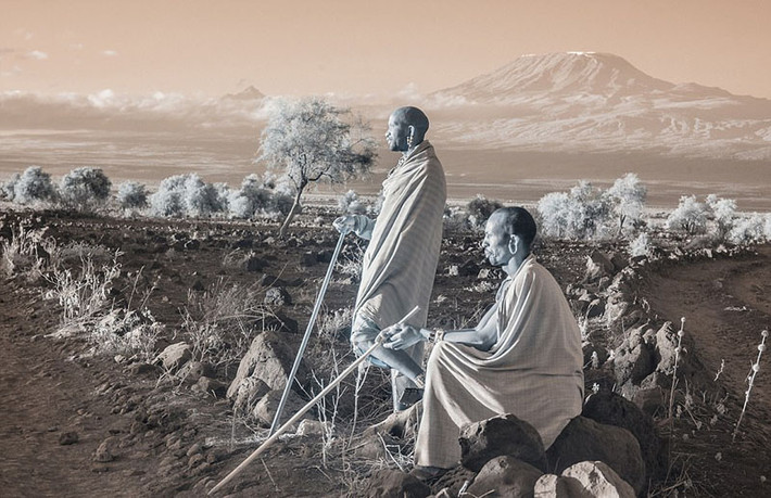Hai người đàn ông thuộc dân tộc Masai đang nhìn xa xăm, phía sau họ là núi Kilimanjaro. (Nguồn Sina)