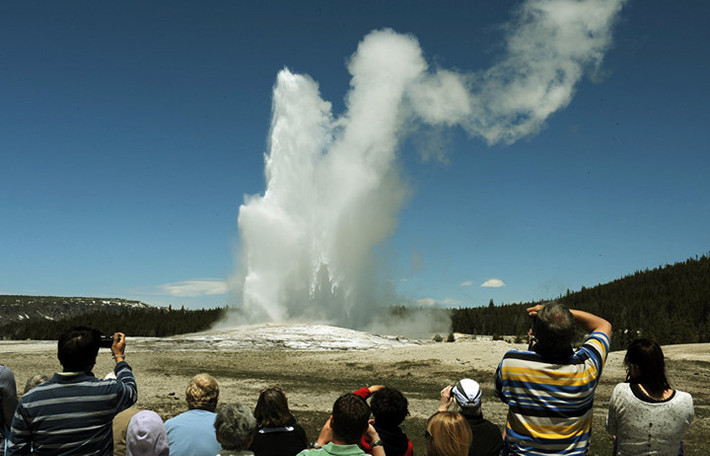 Du khách chiêm ngưỡng mạch nước phun Old Faithful trong công viên quốc gia Yellowstone, Wyoming, Mỹ. Trung bình cứ 90 phút, mạch nước này lại phun một lần. Ảnh: AFP.