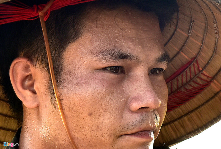 Mồ hôi chảy ròng ròng trên khuôn mặt của một than niên khi gặt lúa dưới nắng nóng tại cánh đồng làng Ngọc Than (Ngọc Mỹ, Quốc Oai, Hà Nội). Ảnh: Việt Hùng.