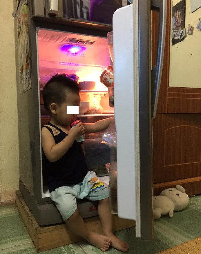 Ngoài điều hòa, tủ lạnh là nơi mát nhất trong nhà. Không ít em nhỏ, kể cả người lớn, thường xuyên tìm đến chiếc tủ lạnh để hạ nhiệt. Ảnh: Lê Huân.