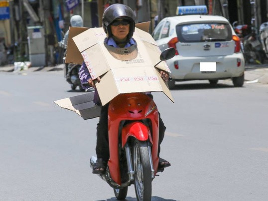Đội bìa là cách chống nắng được nhiều người lựa chọn khi ra đường trong thời điểm này. Ảnh: Beat.