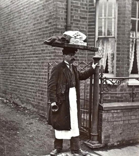 Một người đàn ông đội trên đầu những chiếc bánh Muffin đi bán, tại London vào năm 1910.