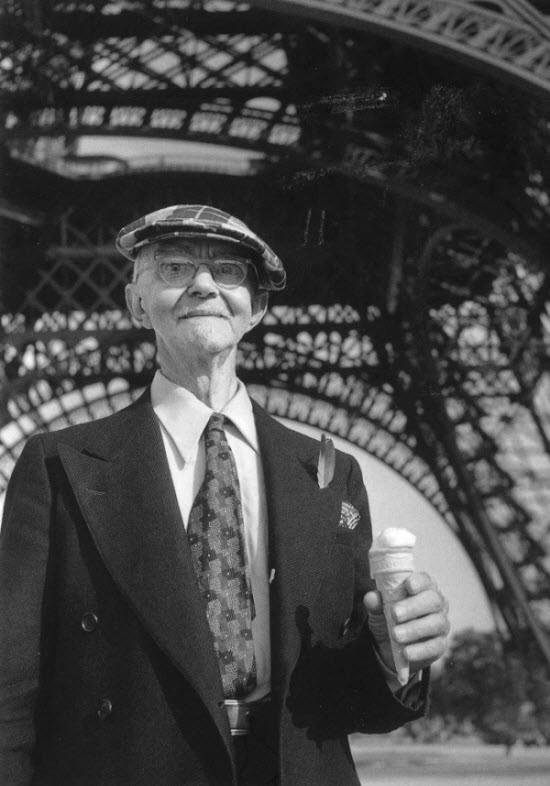 Một du khách đang cầm trên tay chiếc kem ốc quế và đứng tại dưới chân tháp Eiffel vào năm 1950.