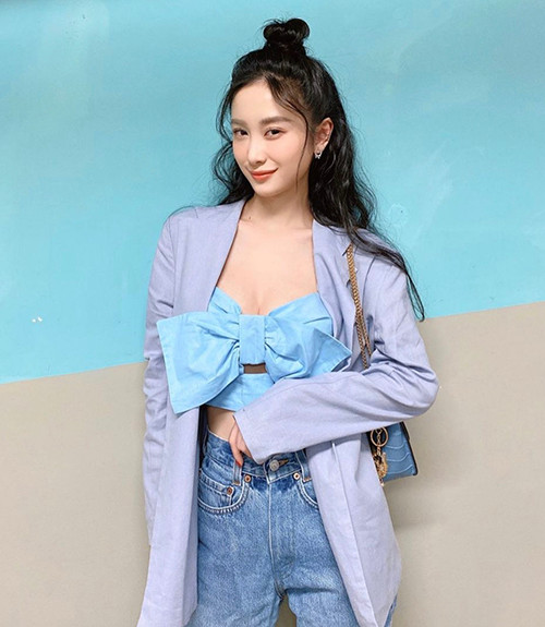 Jun Vũ mix đồ cá tính với áo nơ màu xanh và chiếc áo khoác màu ghi.