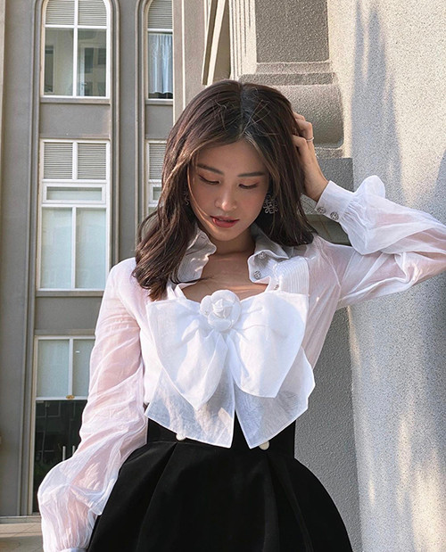 Áo chiếc nơ thiết kế trên chất liệu thoáng mát được Đông Nhi mix cùng váy lưng cao tông màu tương phản.