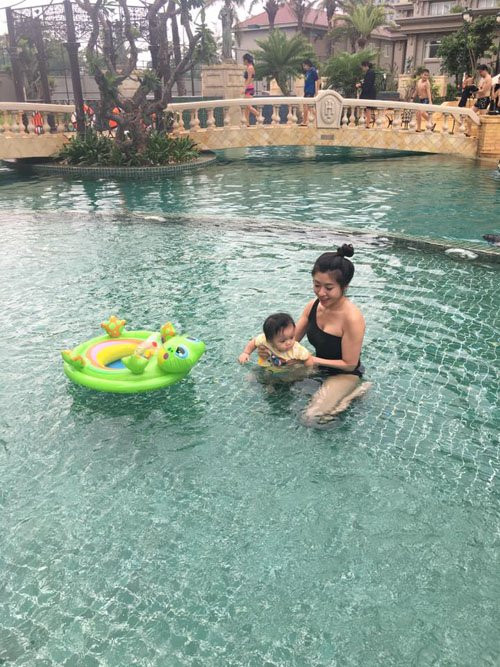 Cô thích thú dạy con gái tập bơi.