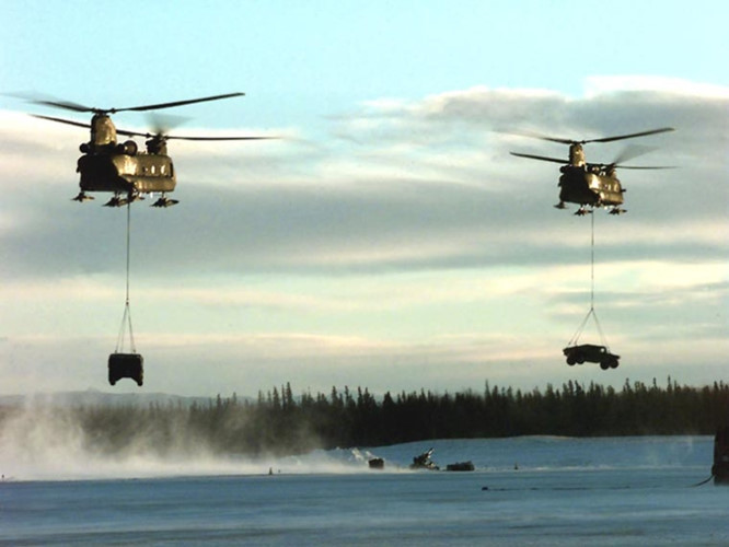 Hai chiếc trực thăng CH-47 Chinook chuẩn bị "thả" xe quân sự xuống nơi tập kết.