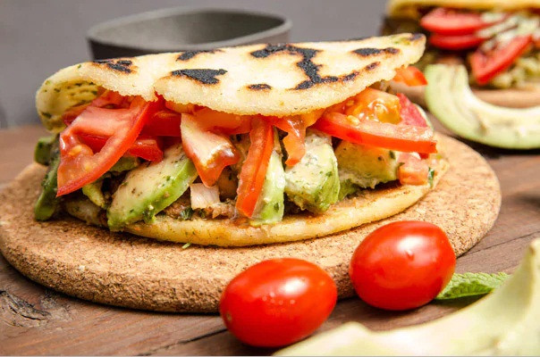 Arepas được làm từ rất nhiều nguyên liệu khác nhau như phô mai, thịt, ngô, bơ,.. sau đó nướng trên một tấm đất sét.