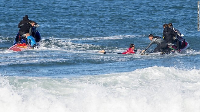 Fanning (áo xanh) và Julian Wilson (áo đỏ) được lực lượng cứu hộ đưa lên mô tô nước. Cả hai đều bị cá mập tấn công khi đang lướt ván.