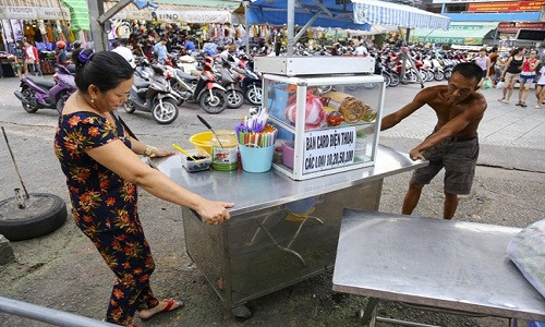 Từ khoảng 17h50 hằng ngày, nhiều tiểu thương bắt đầu dọn hàng quán ra trước cổng mặt tiền chợ Phạm Văn Hai, quận Tân Bình, TP.HCM để buôn bán, đây là khu chợ tập kết bán hàng rong hợp pháp đầu tiên của Sài Gòn.