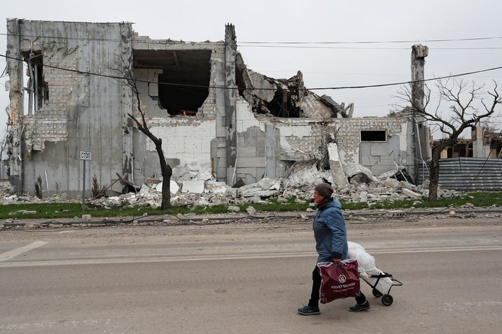 Trên đường phố Mariupol, những người dân Ukraine vội vã đi qua những toà nhà bị cháy rụi, đổ nát rải rác trên đường, cố gắng sơ tán khỏi các ngôi nhà bị phá huỷ. Ảnh: Reuters.