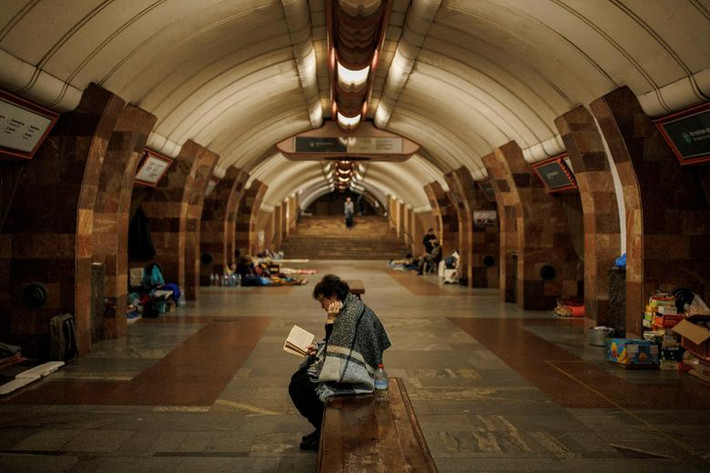 Người phụ nữ đọc sách trong lúc trú ẩn trong ga tàu điện ngầm ở Kharkiv, Ukraine để tránh những đợt pháo kích.
