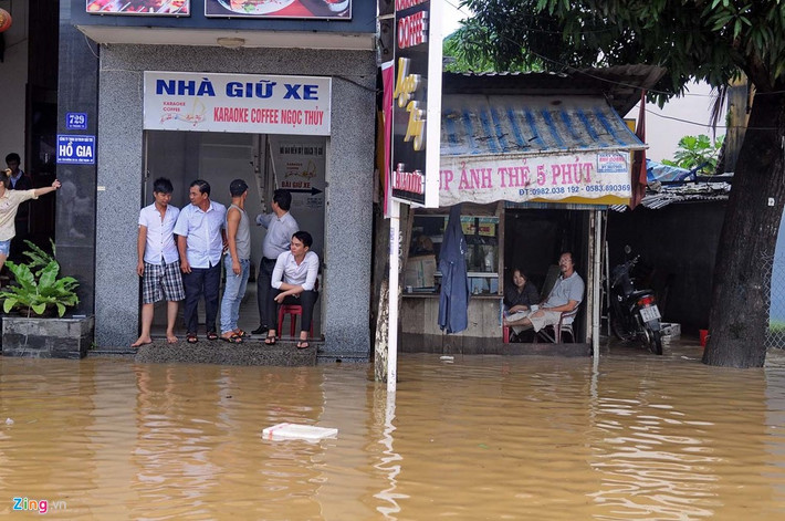Người dân ngán ngẩm ngồi trong nhà nhìn ra ngoài.