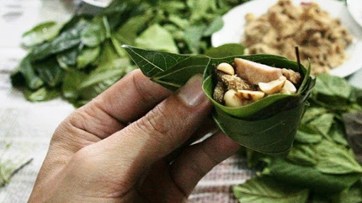 Cuốn hết các nguyên liệu vào miếng bánh đa nem, chấm vào thứ mắm hạt sệt sệt, nhai thật từ tốn để cảm nhận hết vị ngọt của cá, vị bùi của lạc rang, cả vị thơm nồng béo ngậy, mùi hăng hăng của rau, vị chát từ chuối xanh khiến không ai có thể quên được. Ảnh: Internet.
