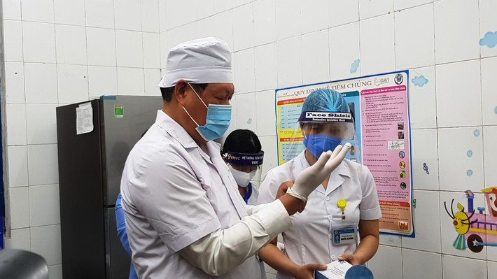 Thứ trưởng Bộ Y tế Đỗ Xuân Tuyên trực tiếp tiêm vắc-xin COVID-19 cho nữ nhân viên y tế.