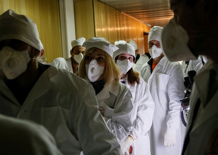 Các nhà báo đi qua khu vực hành lang của lò phản ứng số 3 tại nhà máy Chernobyl.