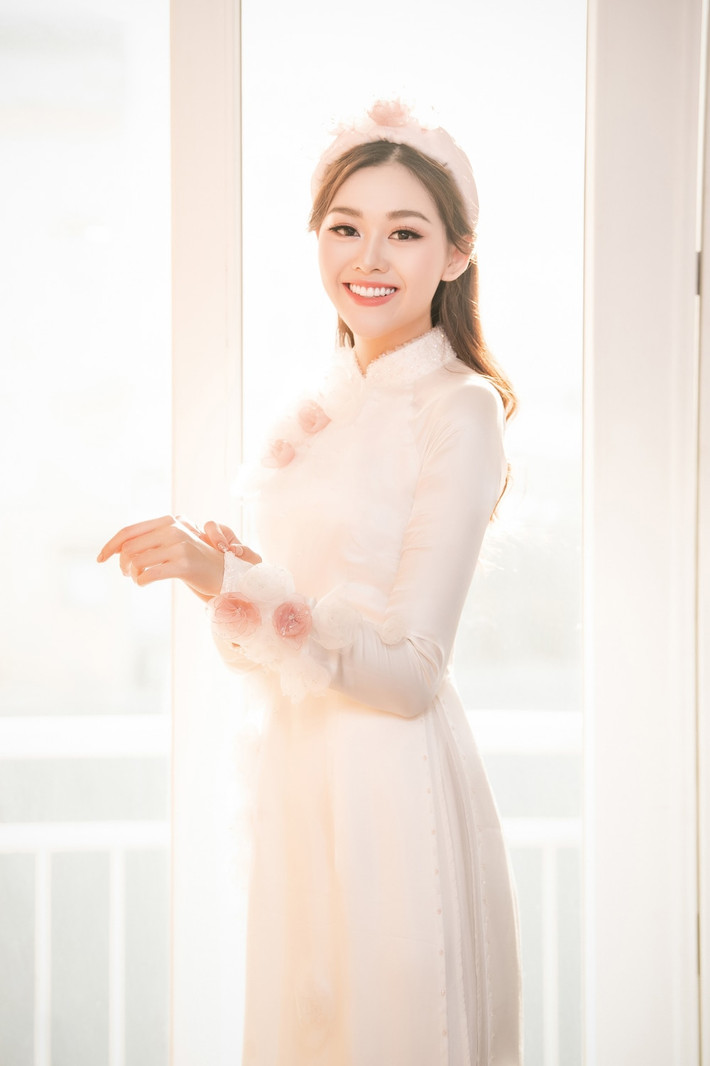 Vào ngày lễ rước dâu, Top 8 Hoa hậu Quốc tế 2019 - Tường San diện áo dài hồng thướt tha, lựa chọn tông trang điểm nhẹ nhàng khoe vẻ đẹp trong veo. Trong những thước ảnh hiếm hoi của ngày lễ trọng đại nhất đời, cô dâu Nguyễn Tường San khiến fan ghen tỵ với chiếc nhẫn kim cương.