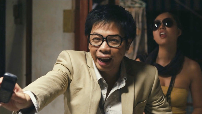 Long Ruồi (2011): Thái Hòa tiếp tục được đạo diễn Charlie Nguyễn "chọn mặt gửi vàng" khi sản xuất dự án Long Ruồi. Trong phim, nam diễn viên cùng lúc đảm nhận hai tạo hình trái ngược là Long - ông trùm xã hội đen khét tiếng và Tèo - người bán bánh xèo từ quê lên thành phố. Tuy hóa thân hai vai, nét diễn của Thái Hòa lại có sự khác biệt và duy trì độ hài hước theo hai tính chất khác nhau. Dự án giúp anh nhận giải Nam diễn viên chính xuất sắc tại Cánh diều vàng năm 2011. Về mặt doanh thu, Long Ruồi thu về 42 tỷ đồng - một con số khổng lồ với phim Việt thời điểm đó. Ảnh: Chụp màn hình.