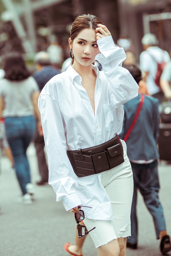 Nữ hoàng nội y còn xuống phố với cây trắng gồm áo sơ mi buông lơi hàng cúc phối với quần bike short cá tính.