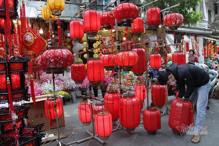 Một chủ sạp hàng bán đèn lồng đỏ đang bày biện đón khách