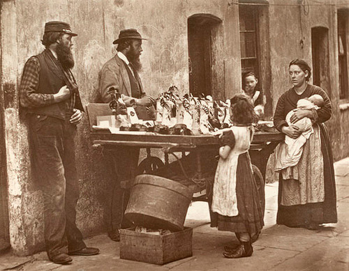 Cuộc sống đường phố ở London, Anh giai đoạn năm 1876 - 1877 hiện lên bình dị, thanh bình. Trong ảnh là một bé gái ngắm nhìn những món đồ bày bán trên vỉa hè.